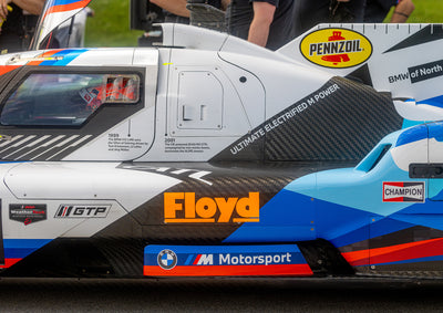 Close-up of a race car with various sponsor logos on a track
