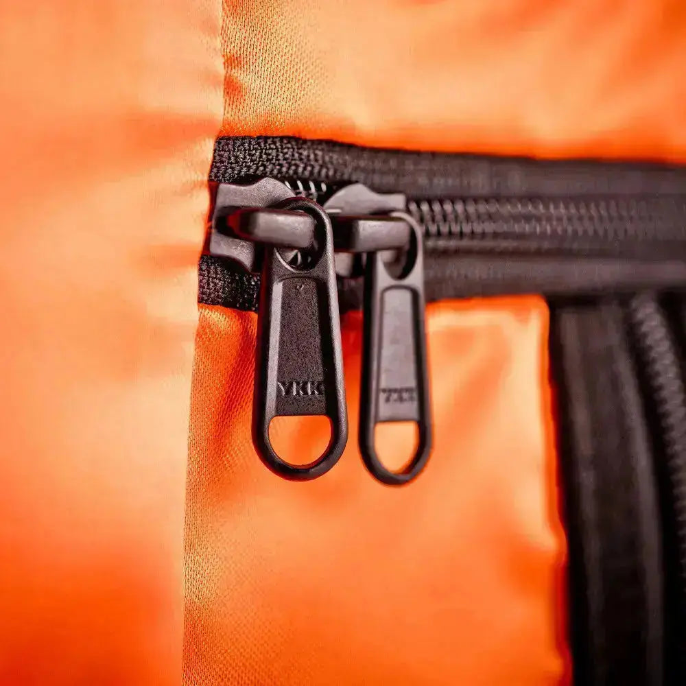 Close-up of the orange Floyd suitcase lining with black YKK zippers